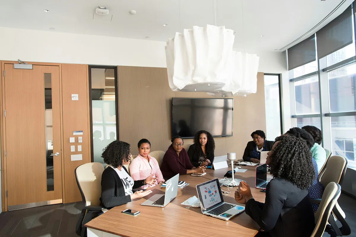 Team meeting around a boardroom table with laptops to plan and streamline AI workflows