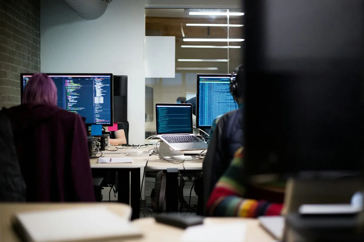 Developers coding in a modern office workspace.