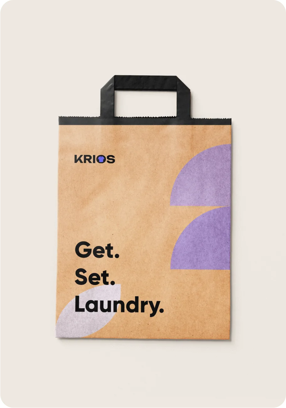 Krios branded paper packaging bag printed with “Get. Set. Laundry.”