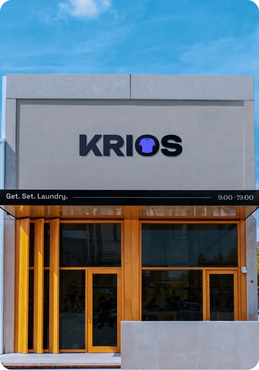 A Krios storefront with exterior signage reading “Get. Set. Laundry.”